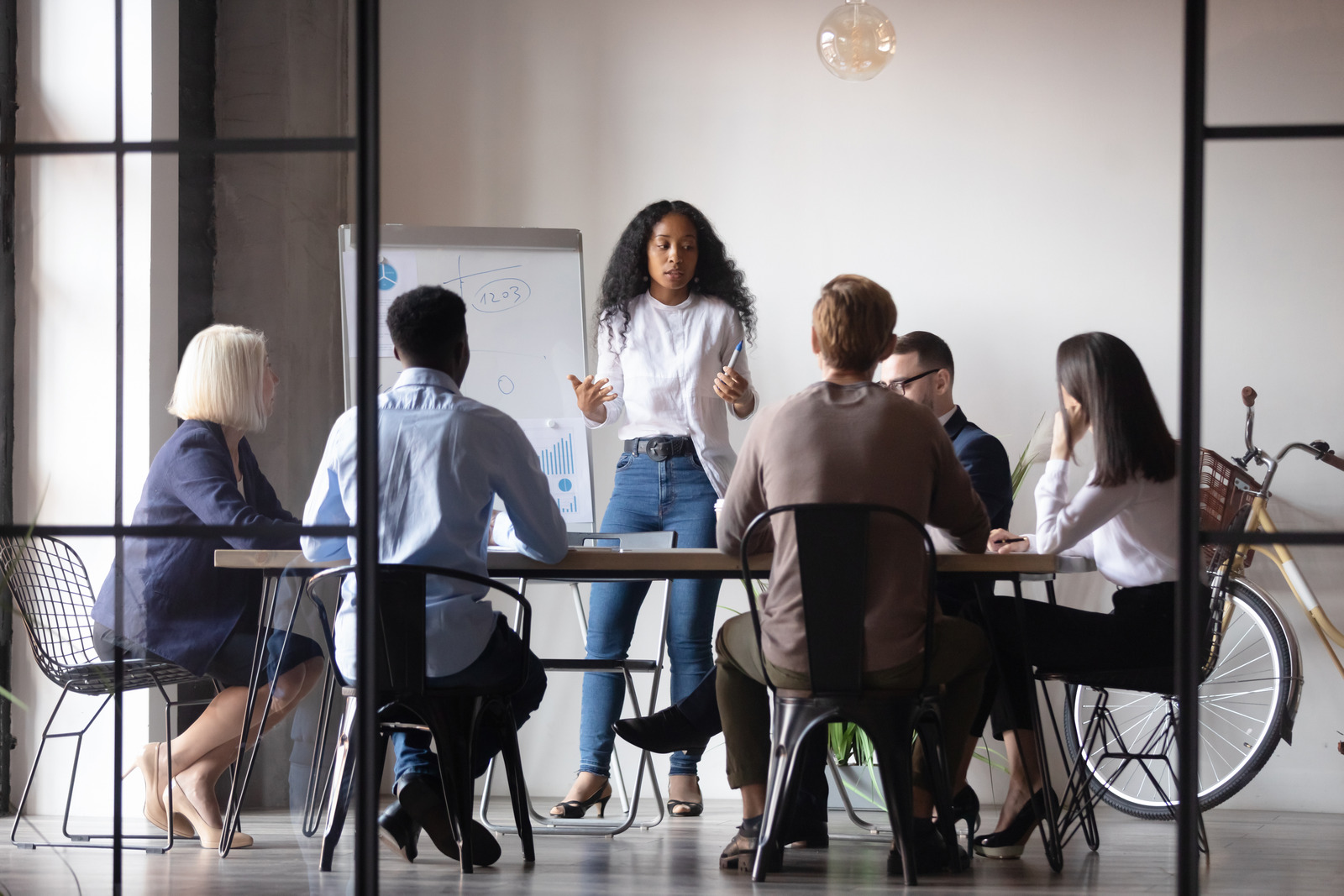 A team leader facilitating a discussion with her team around a meeting table