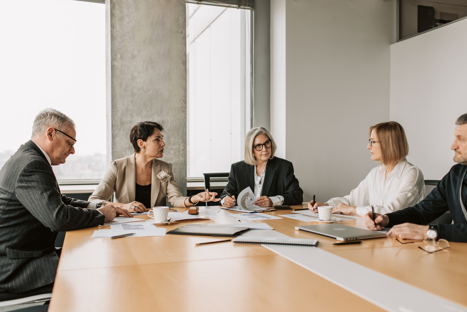 Senior managers in discussion around a boardroom table